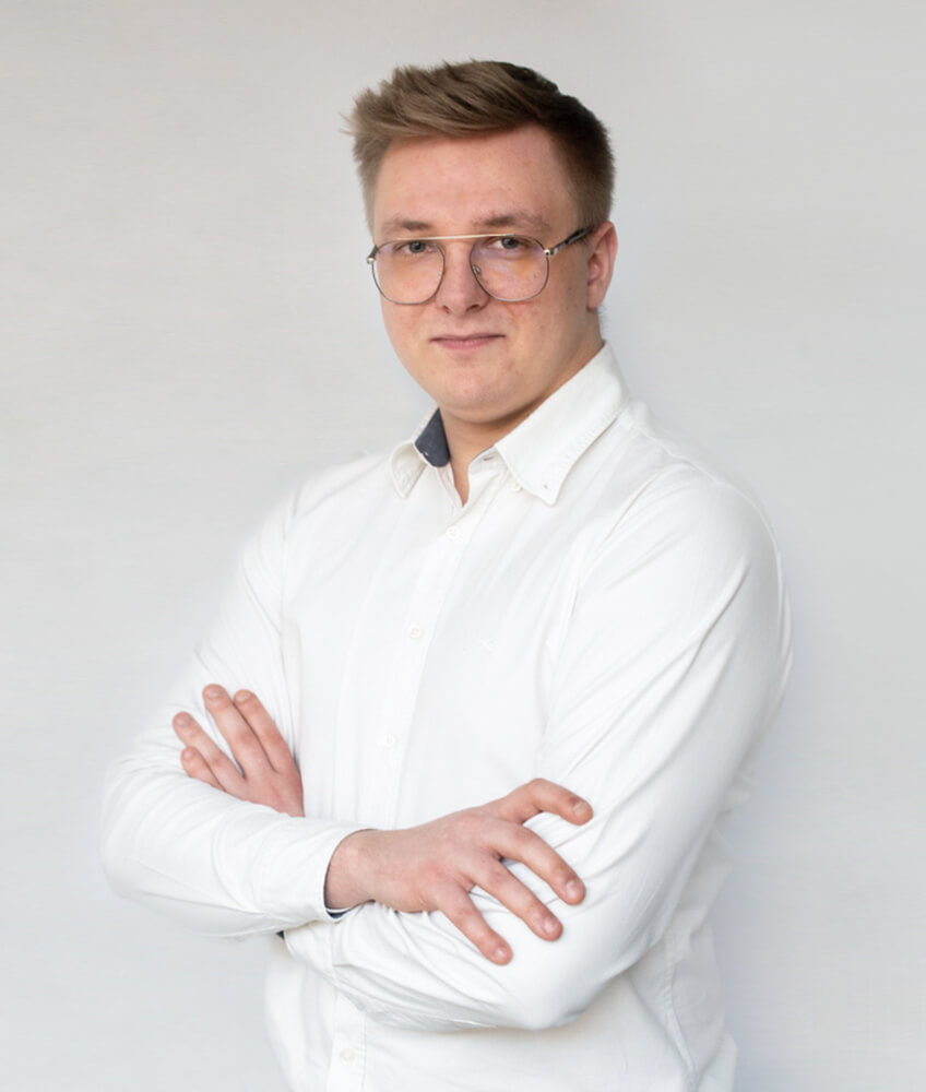 Portret Pawła Siemińskiego, młodego mężczyzny w białej koszuli, pełniącego funkcję managera projektu w agencji Click Leaders