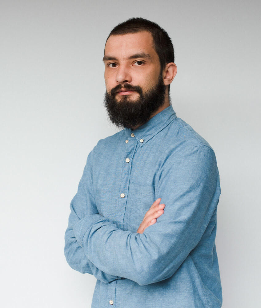 Portret młodego mężczyzny z brodą, w błękitnej koszuli - Tomasz Ankowski, dział programistów w agencji Click Leaders